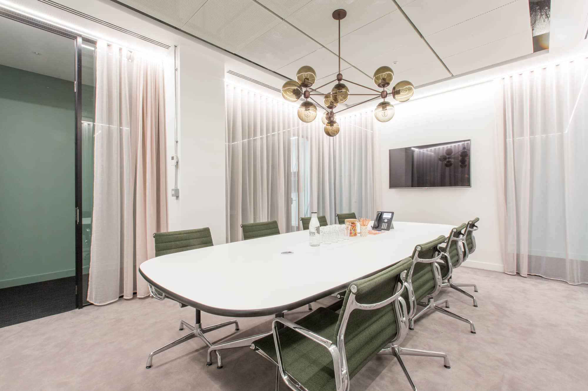 Bright meeting room with table and chairs and a display screen at 2 Stephen Street.